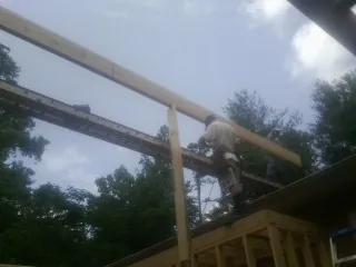 Carpenter setting a ridge beam over a new addition frame — Ice Dam Removal by Roofing Brothers in Oregon City
