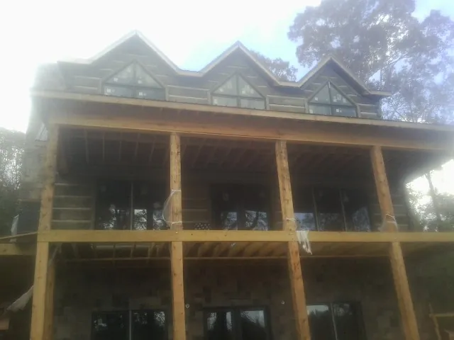 Dormers and porch framing on a large log home under construction — Roof Coating work by our crew in Oregon City
