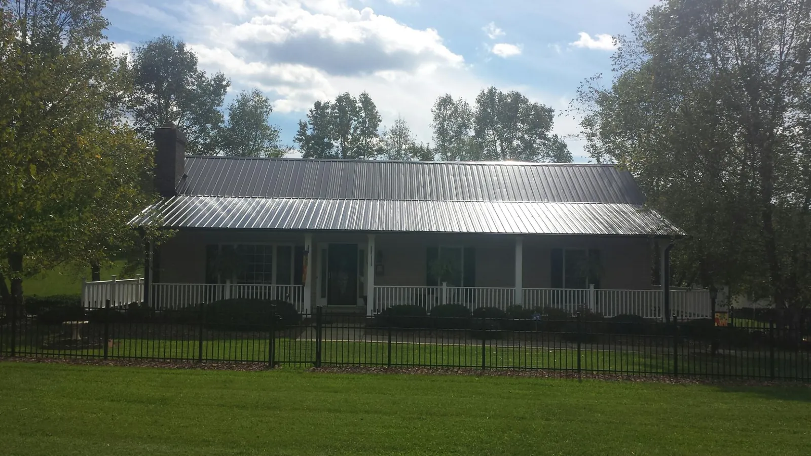 Gray metal roof on a brick ranch with a full width front porch — Gutter Guard Installation work by our crew in Oregon City
